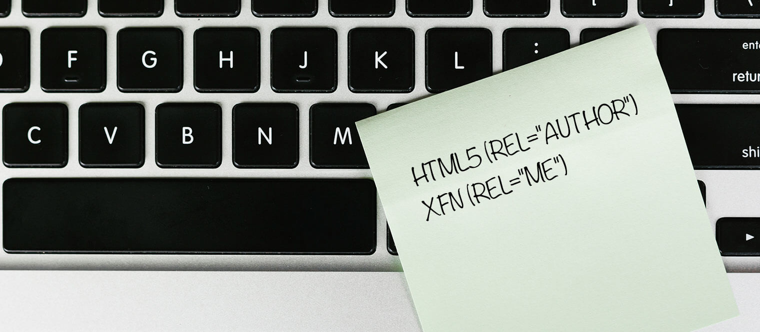A laptop with code written on a sticky note.