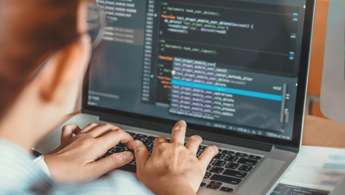 a woman alters the mark-up code on her website to optimise it for GEO