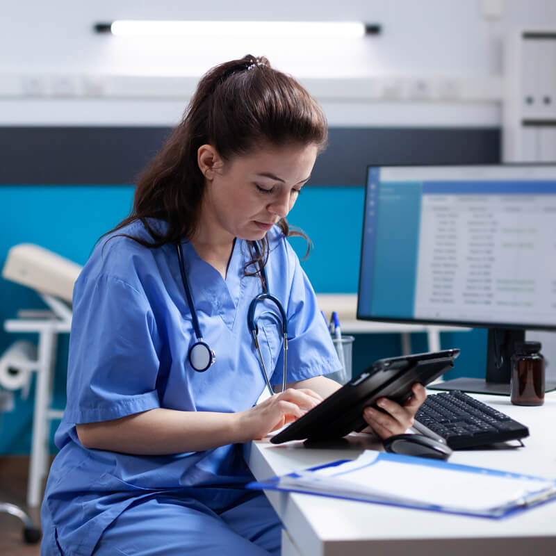 an NHS doctor using their tablet device in a surgery office