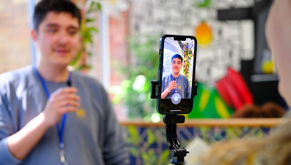 an influencer being filmed on a mobile phone rig for social media