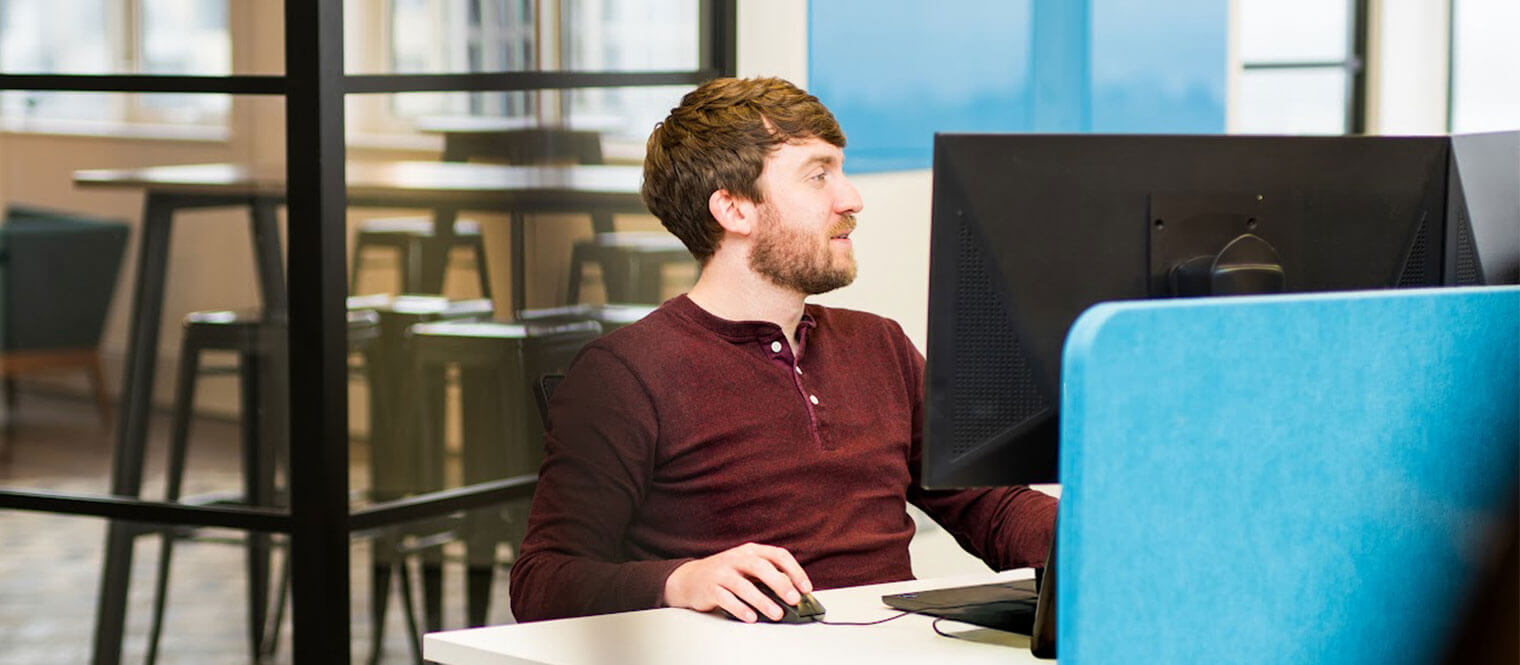 Adam working at a desk on a computer.