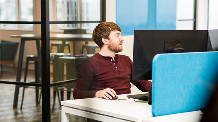 Adam working at a desk on a computer.
