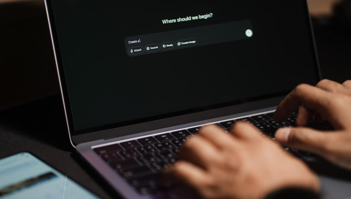a man typing a prompt into a ChatGPT chat on his laptop