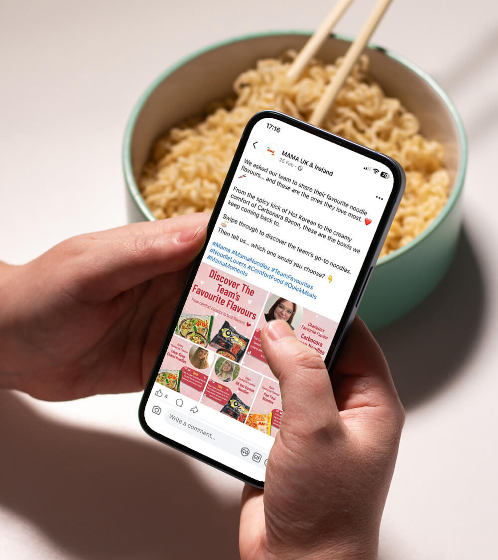a person looking at the MAMA Noodles Facebook page with a bowl of noodles in the background