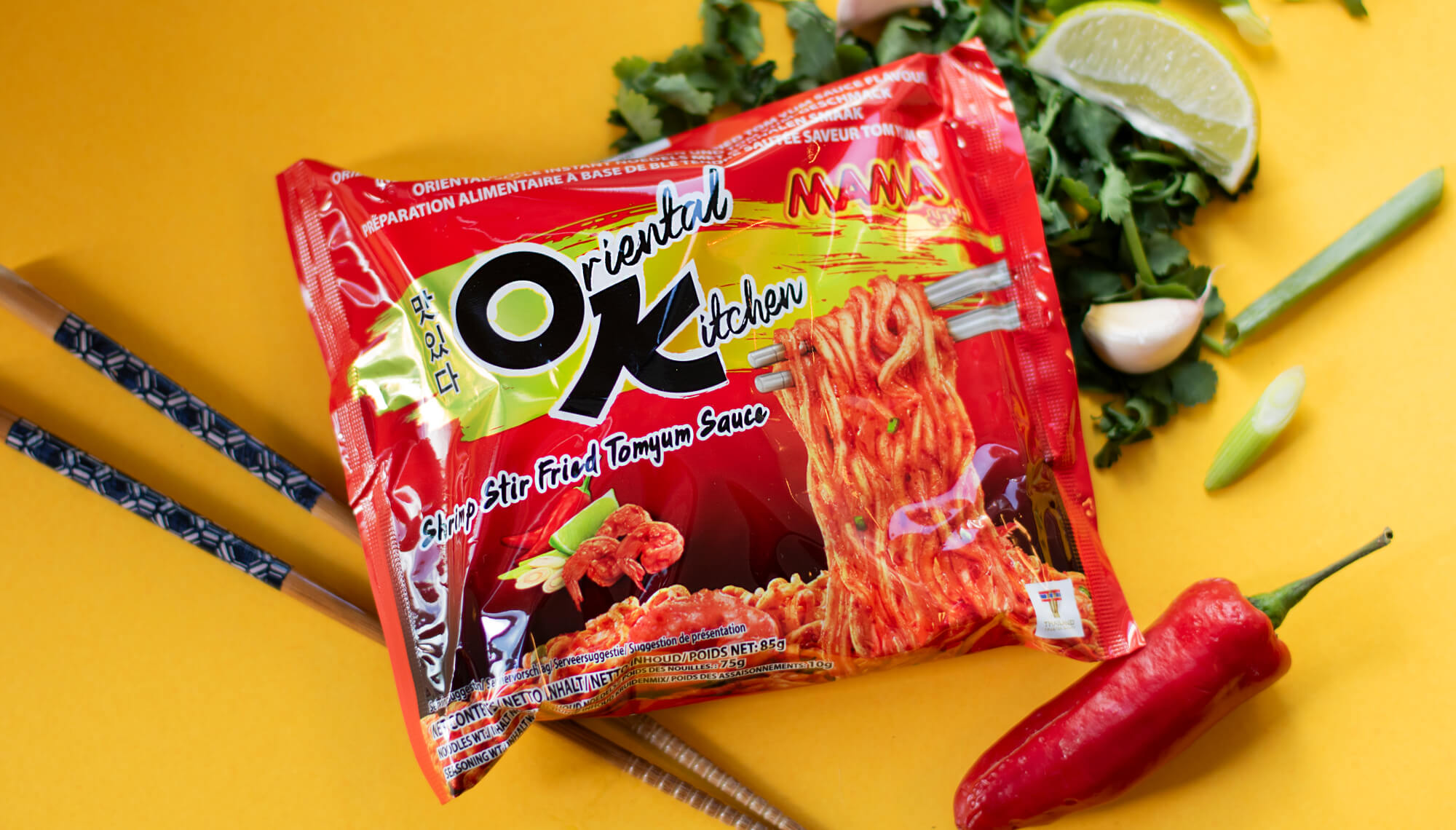 a bright red packet of instant noodles and wooden chopsticks on a vibrant yellow background