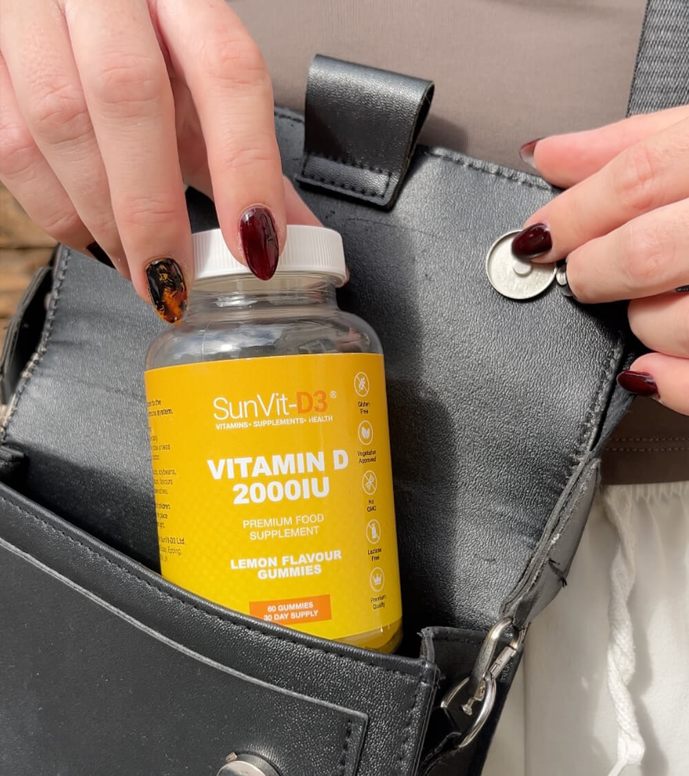 a woman pulling vitamin d vitamin gummies out of her handbag