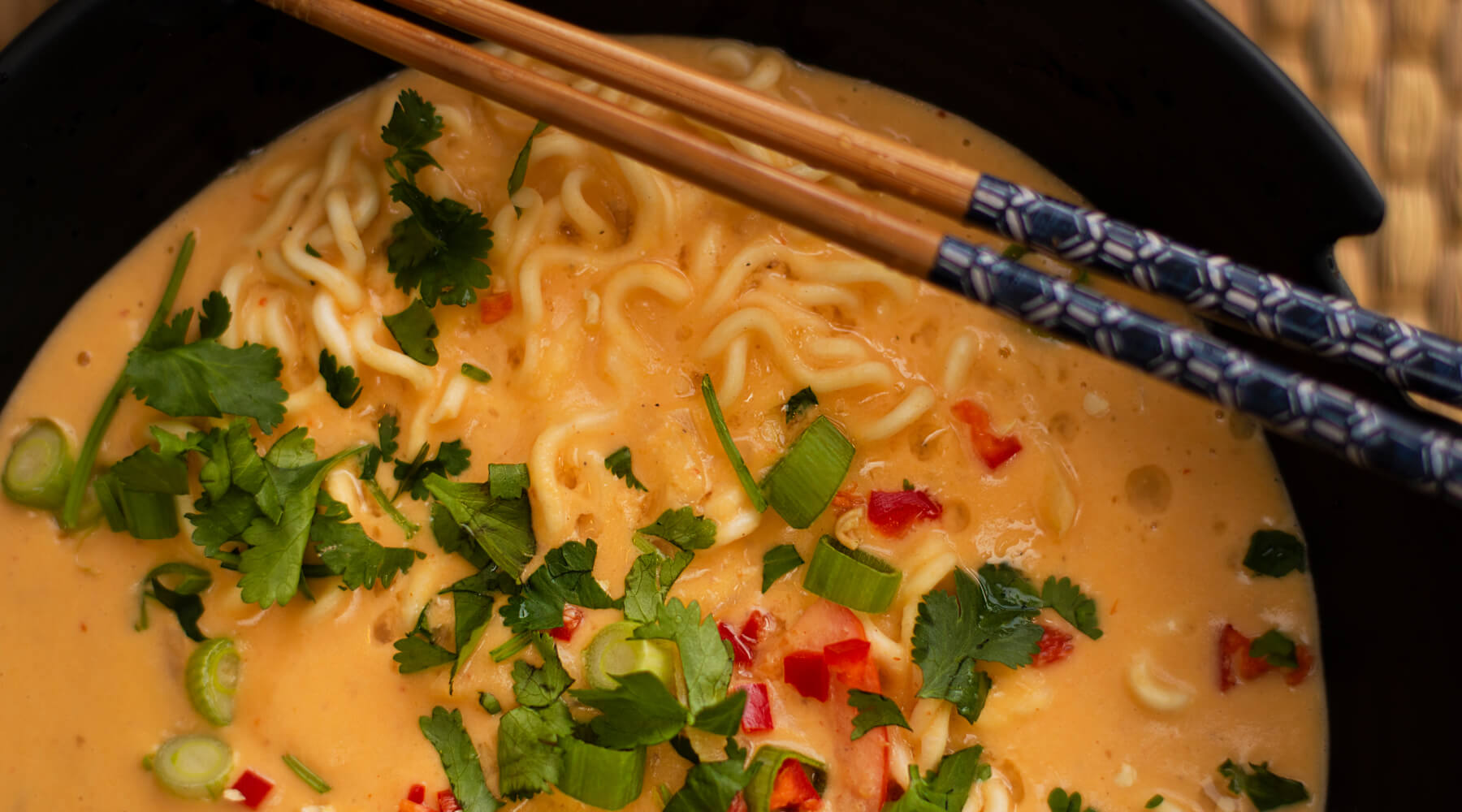 a bowl of fresh MAMA brand ramen noodles with chopped chillies and coriander