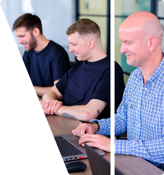 Toby and the team sat at a large desk working on laptops.