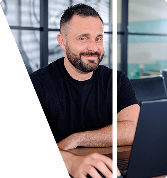 Michael smiling using a laptop.