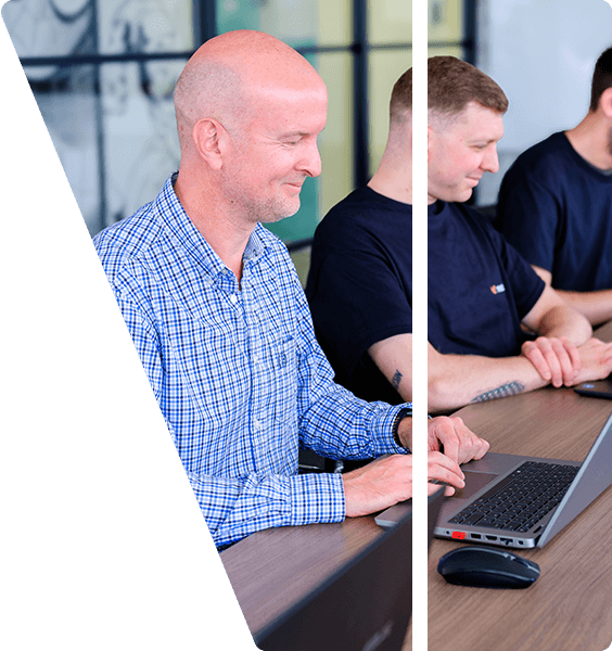 Toby and the team sat at a long desk working on laptops.