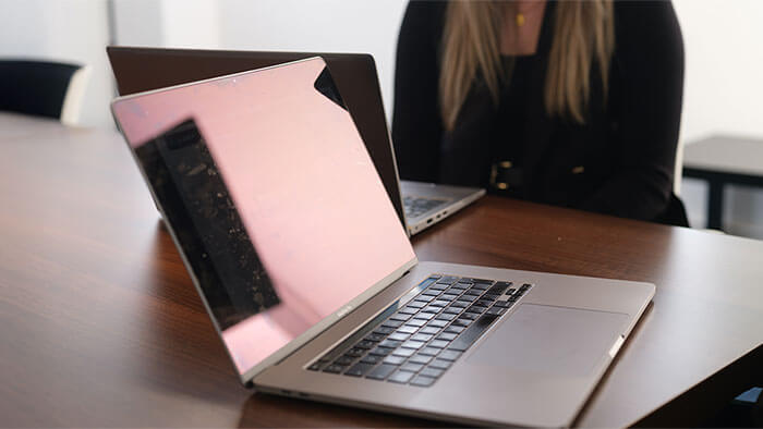 An open laptop on a large meeting room desk.