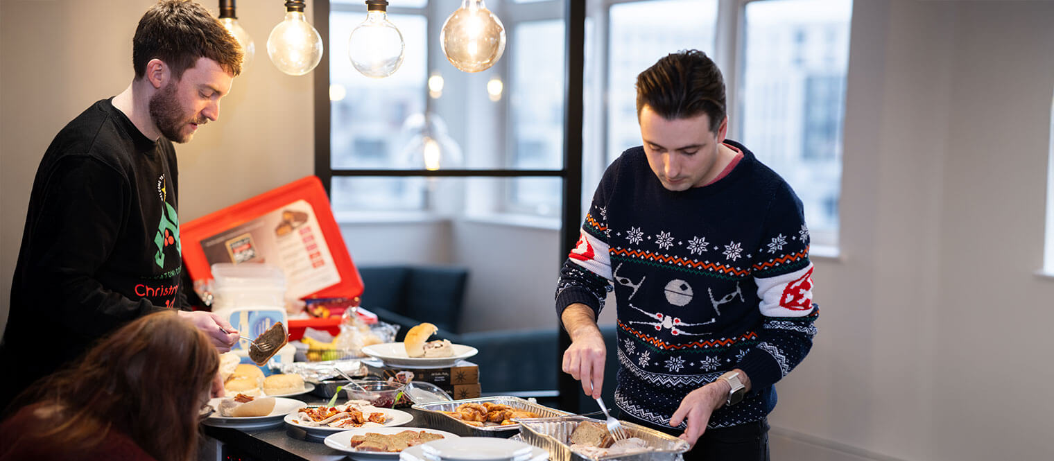 The team eating food from the Xmas buffet spread.