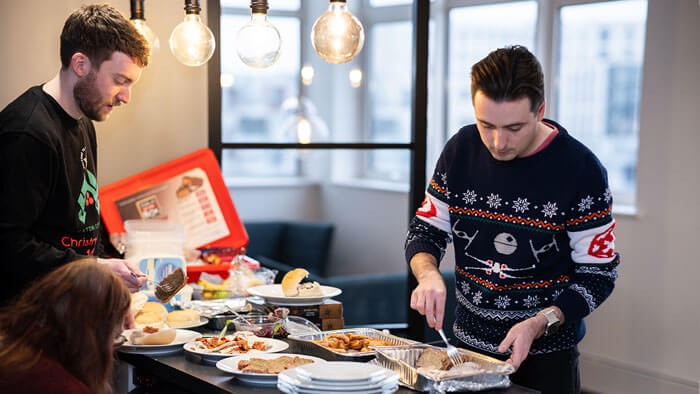 The team eating food from the Xmas buffet spread.