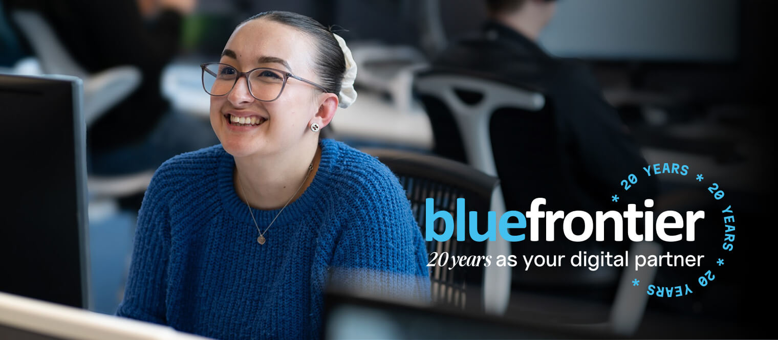 a young employee smiling up at the camera in a bustling and modern open-plan office