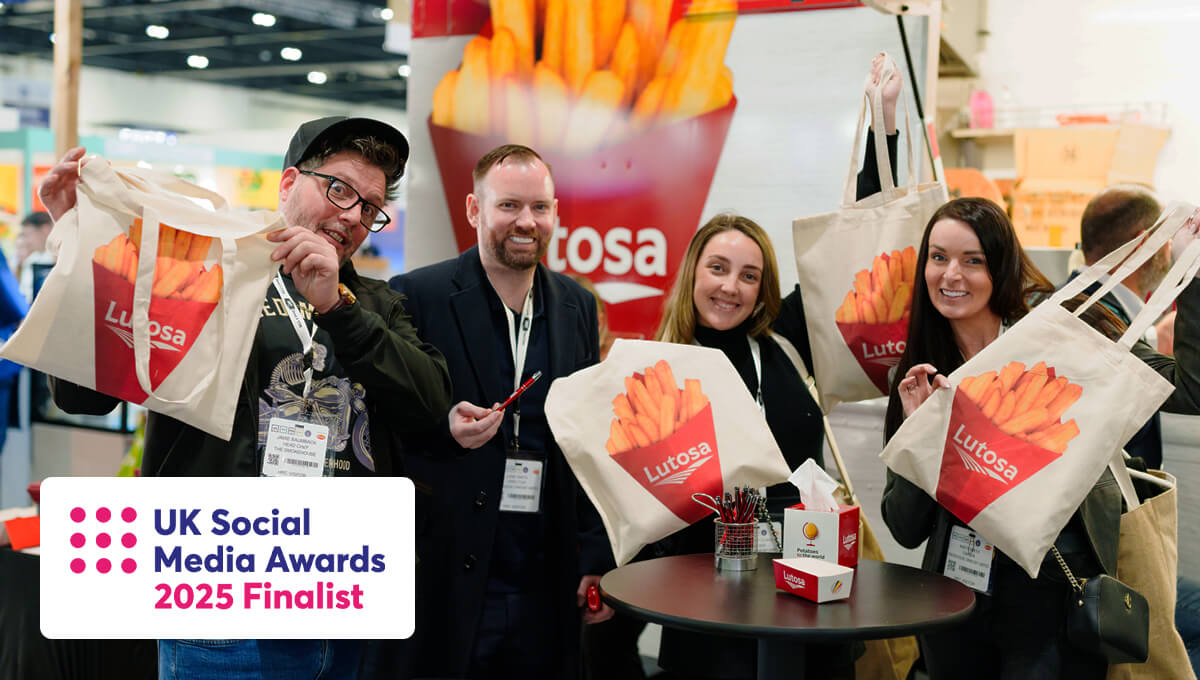 a group of people proudly holding a Lutosa branded tote bag featuring a red cone full of chips