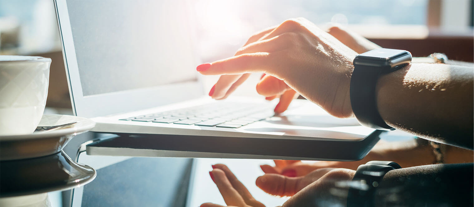 Woman typing on a laptop.