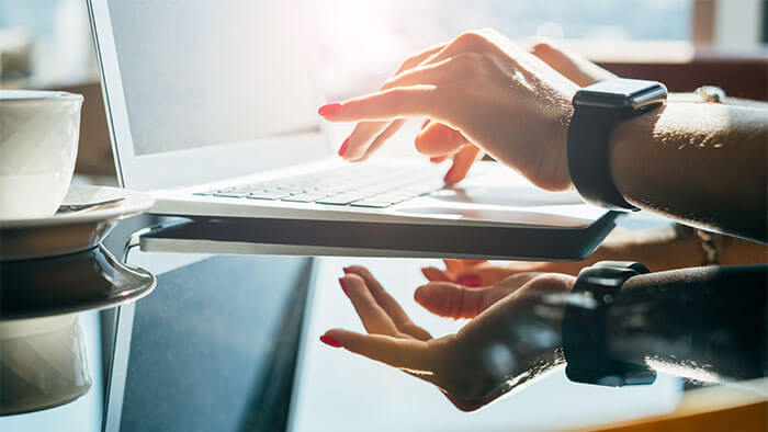Woman typing on a laptop.