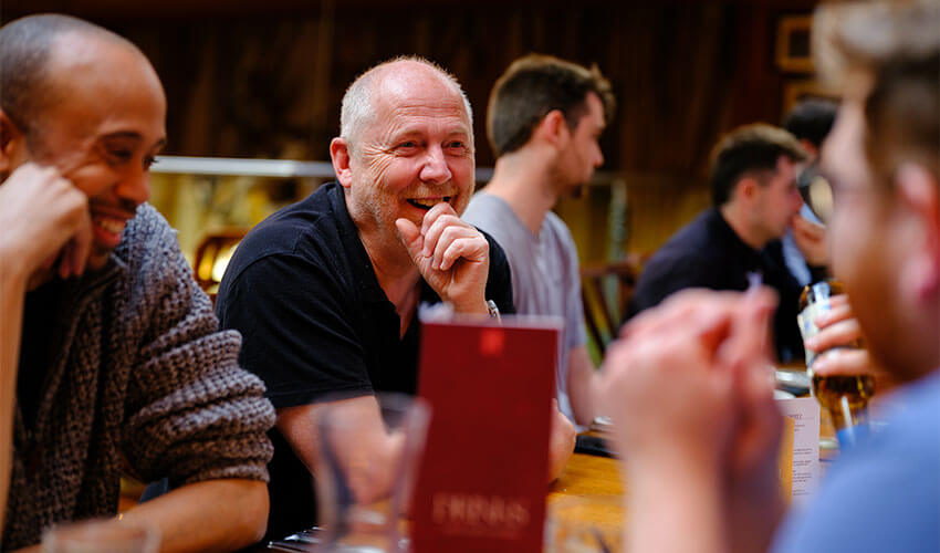 Staff smiling while talking at the conference meal.