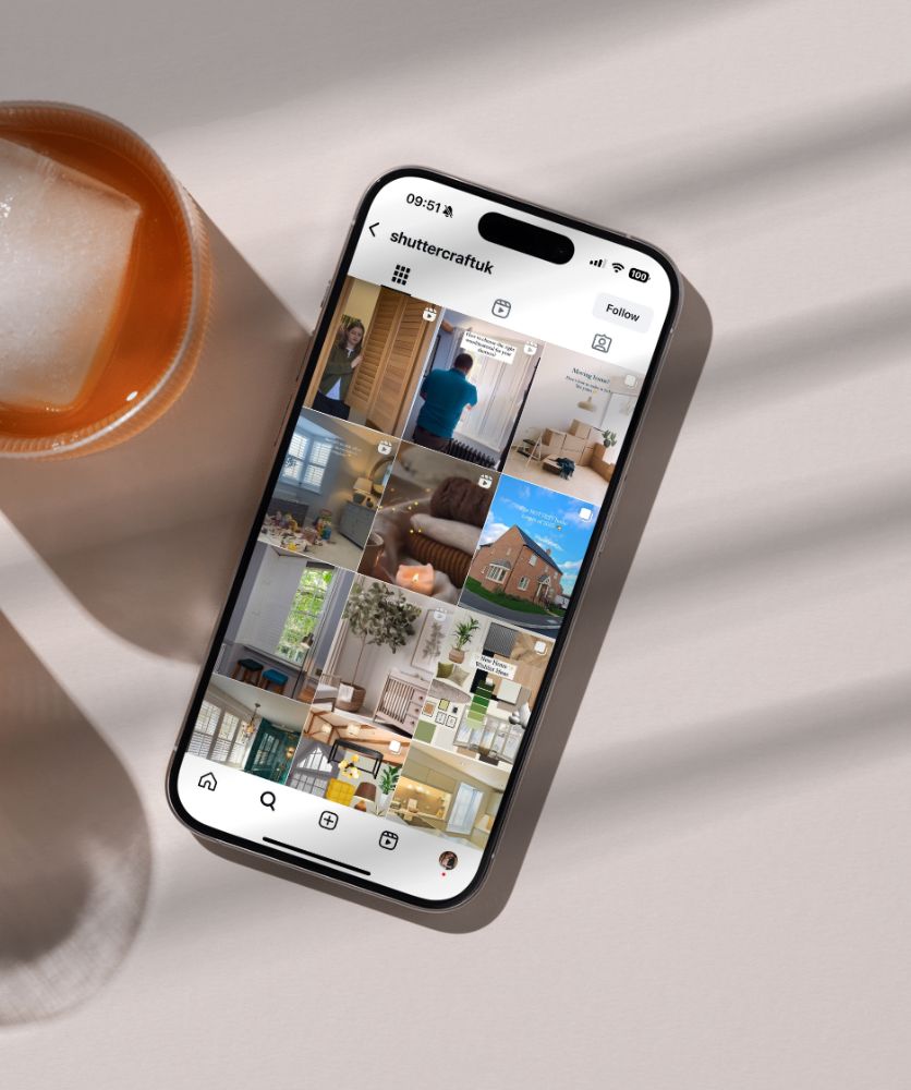 a mobile phone laying on a table surface with an image gallery app on the screen