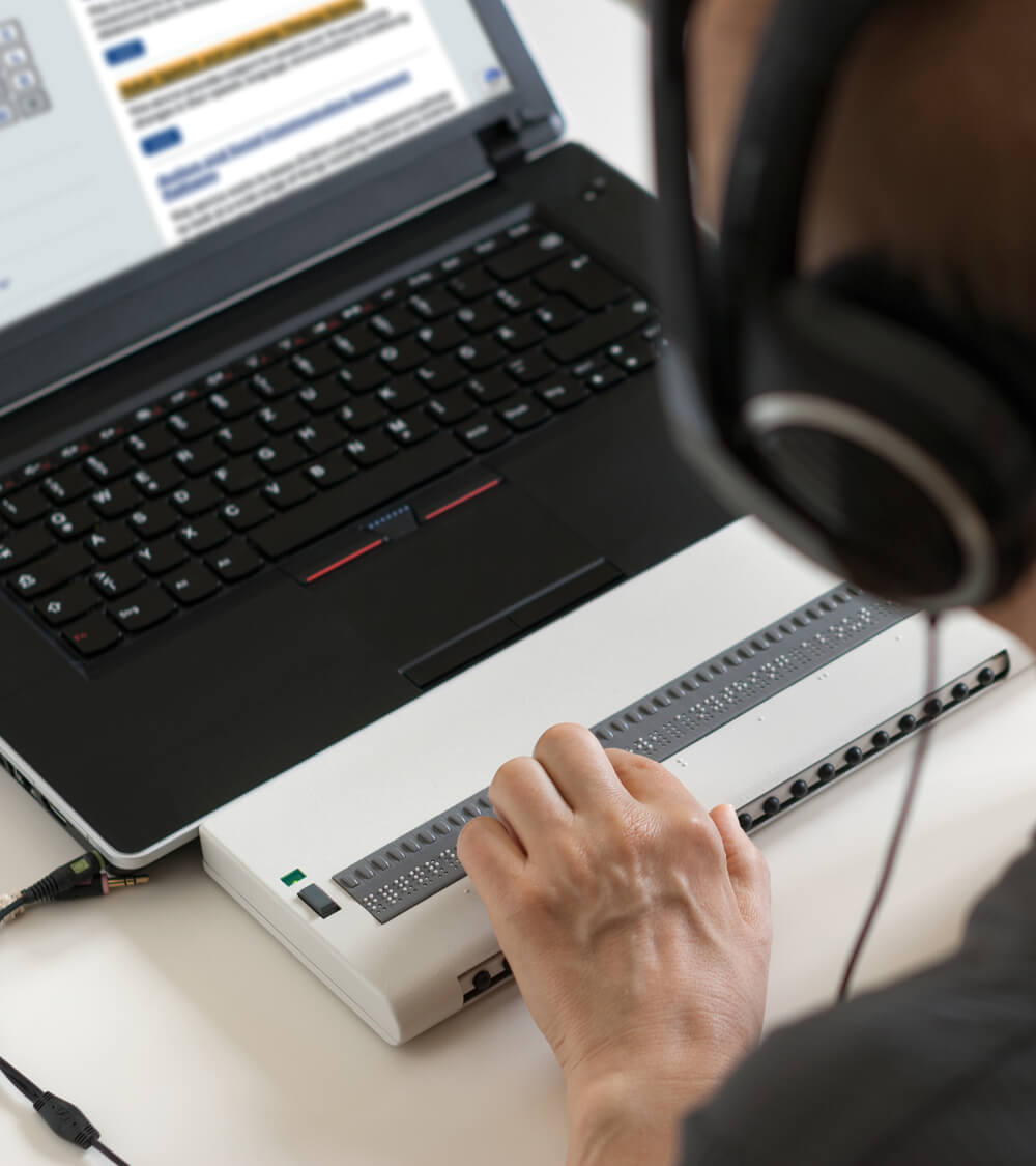 a blind person navigates an NHS website using a text to braille display
