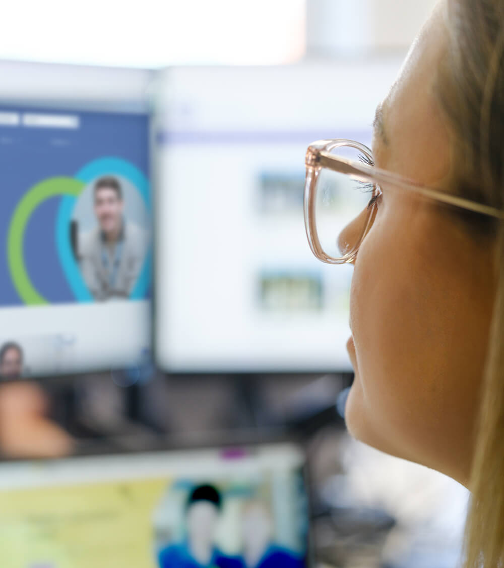 a nurse looks up at her screen whilst using an NHS website