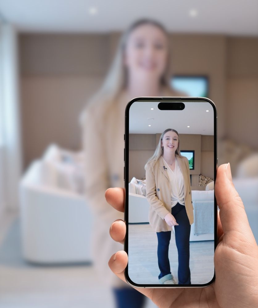 a young woman being filmed on a smart phone in a bright room