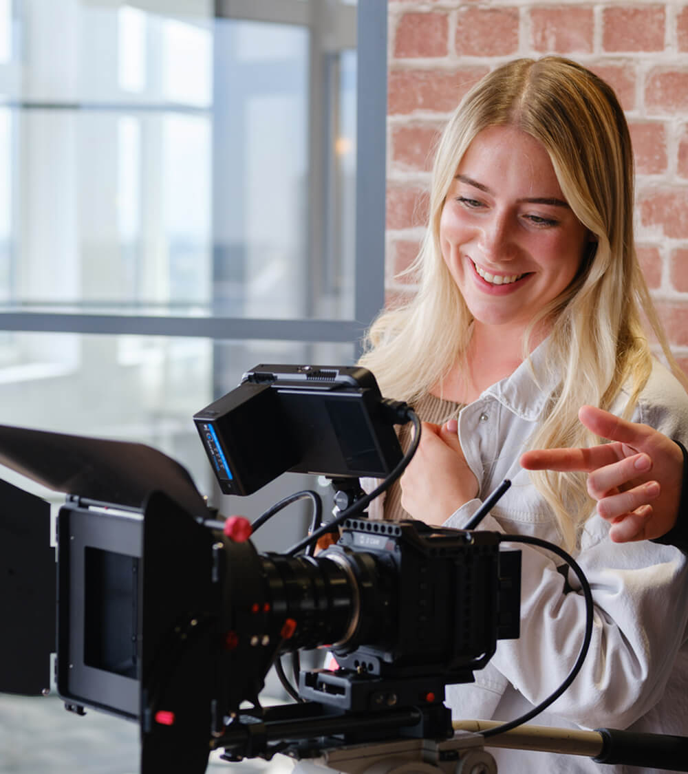 a young woman smiling watching playback on a professional photoshoot