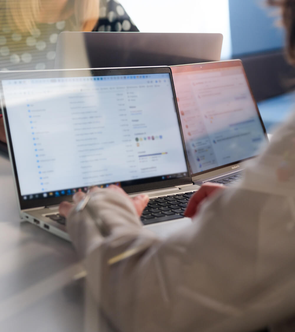 a person obscured by the camera looks at data on a laptop screen