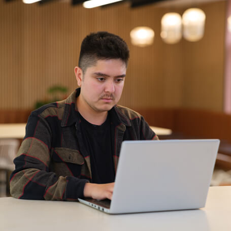 a man concentrates on his laptop in a modern office space