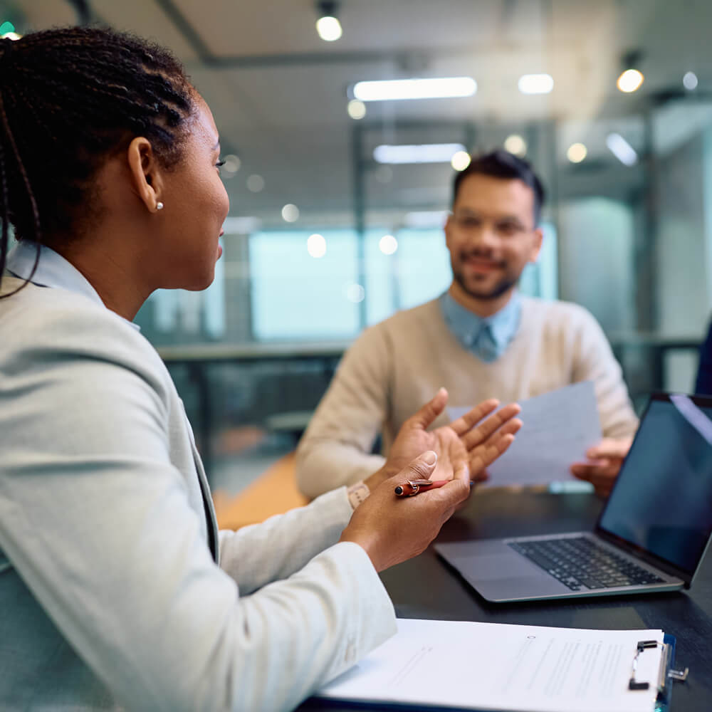 two corporate bankers in a meeting room looking at a laptop
