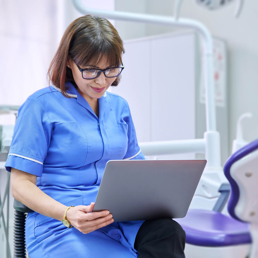 a dental practitioner using her laptop