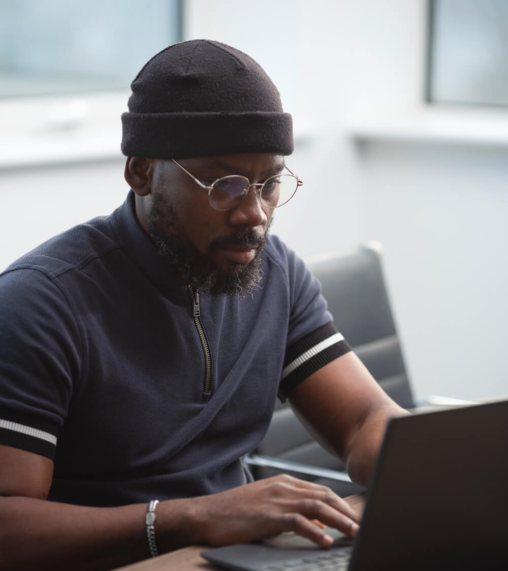 a man using his laptop in a bright office space