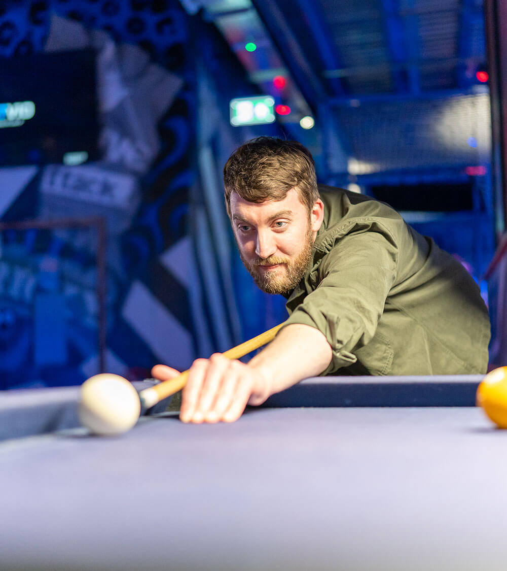Adam playing pool in social event