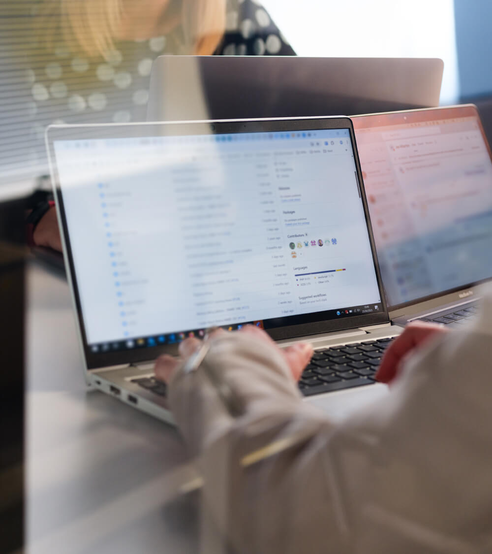 an employee reading their emails on a laptop at a meeting table