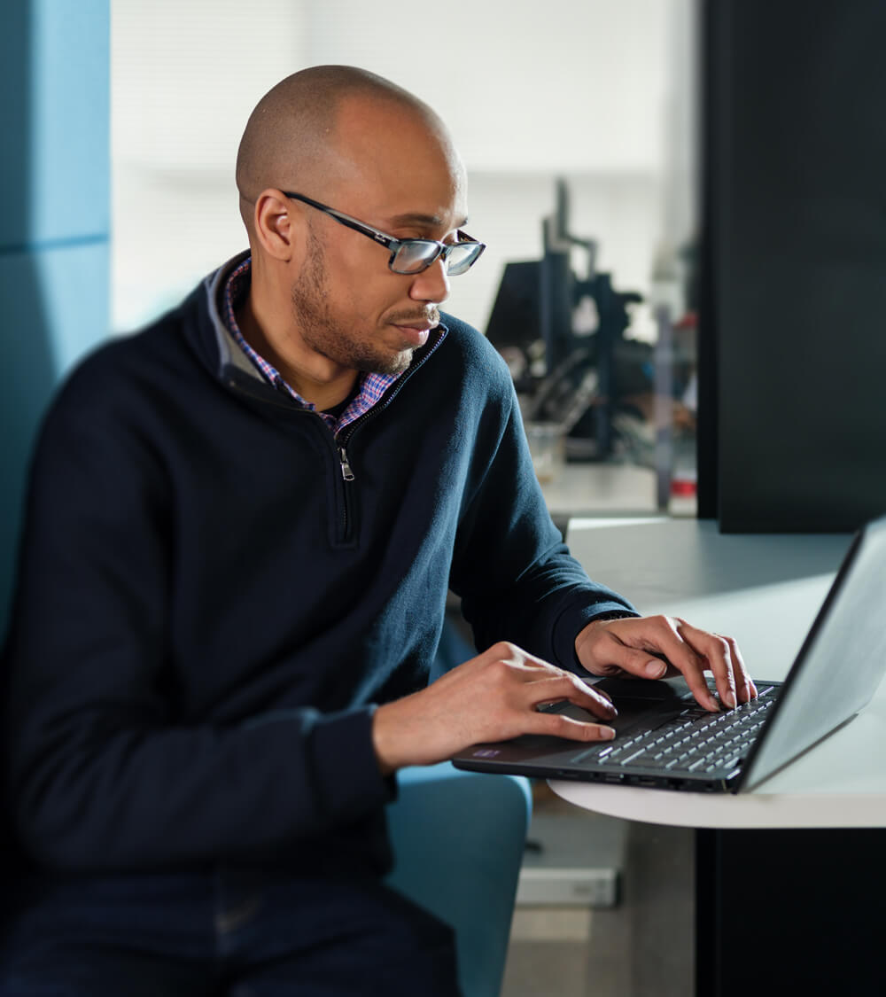 an IT technician setting-up a new laptop in a bright office